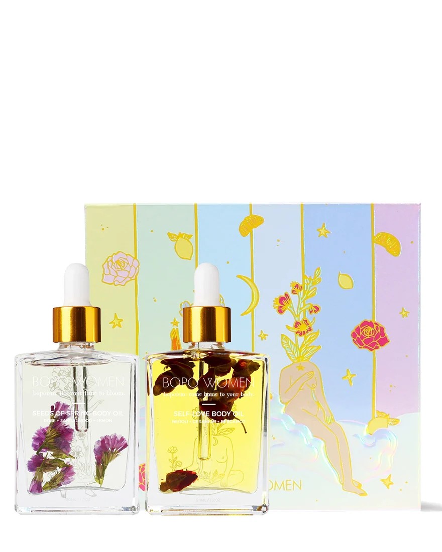 Two perfume bottles with floral designs and a decorative box on a white background