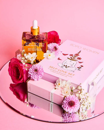 Bath and body products with flowers on a pink background