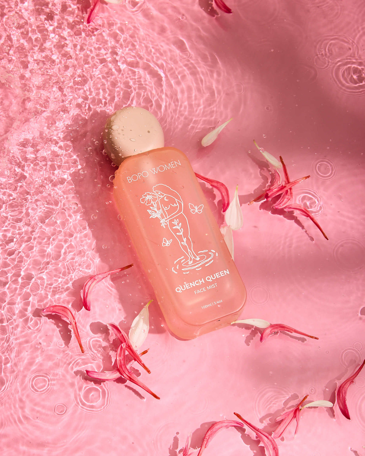 Pink bottle labeled 'Quench Queen' on a pink background with floral elements
