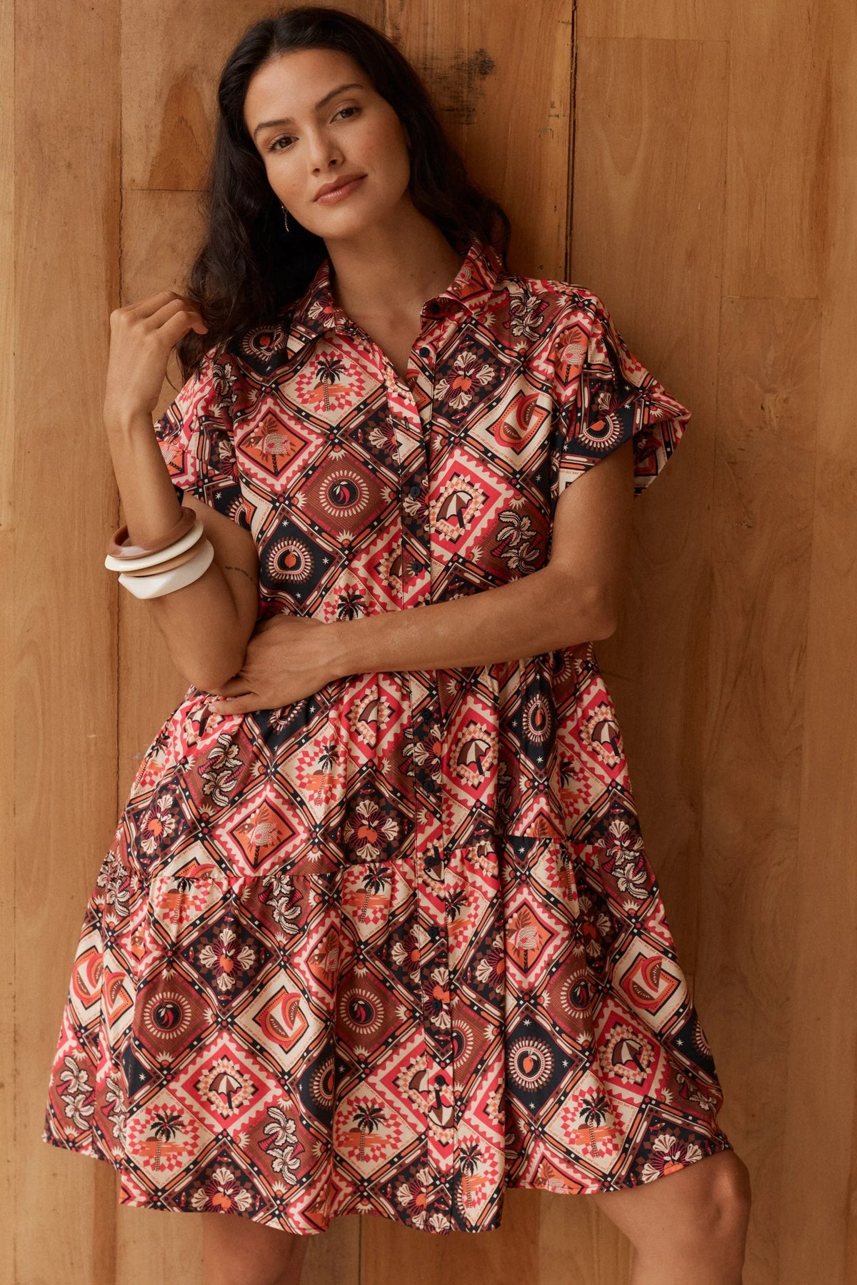 short-sleeve button-up dress with a coluorful geometric and tribal-inspired print in red, orange, black, and cream, 