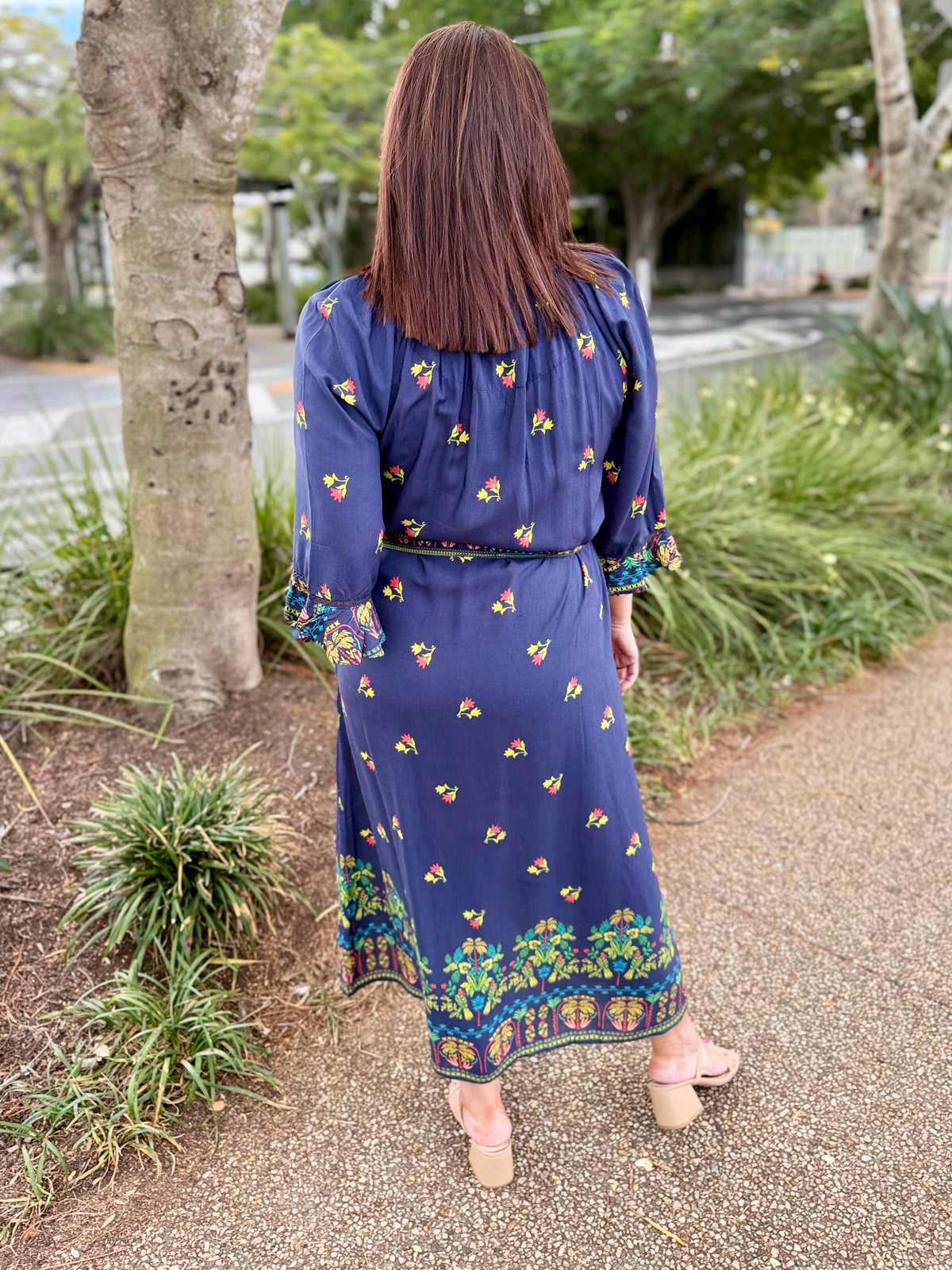 navy blue midi dress with colorful floral prints and green trim 