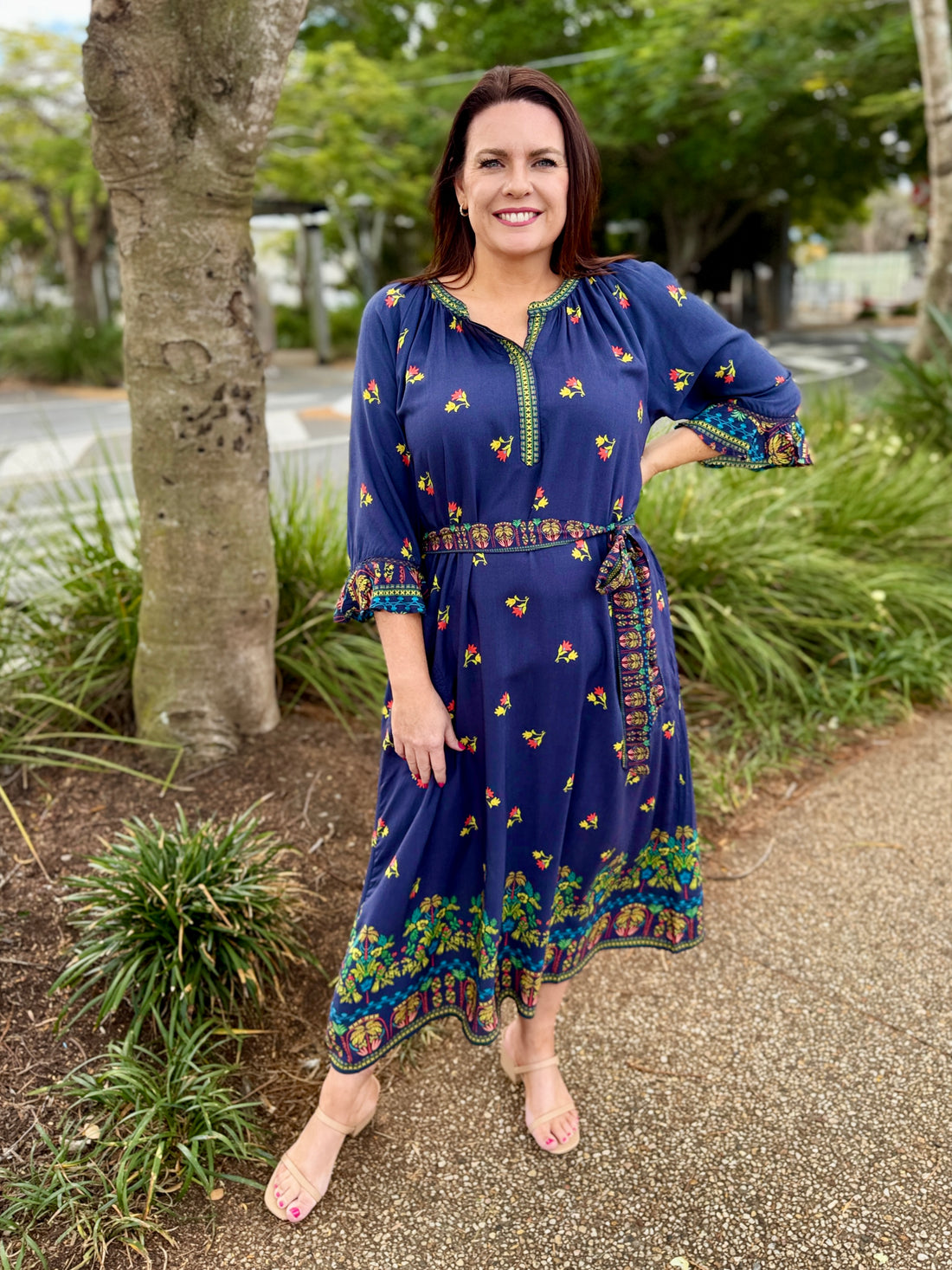 navy blue midi dress with colorful floral prints and green trim 
