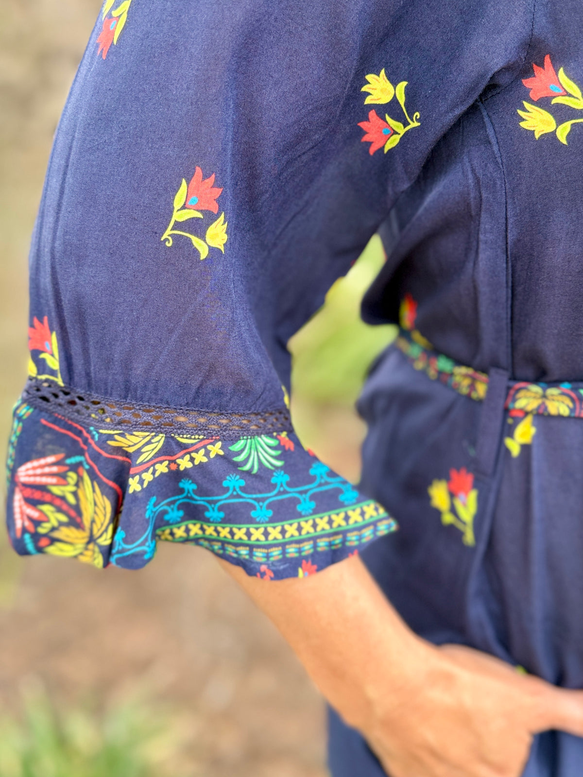 navy blue midi dress with colorful floral prints and green trim 