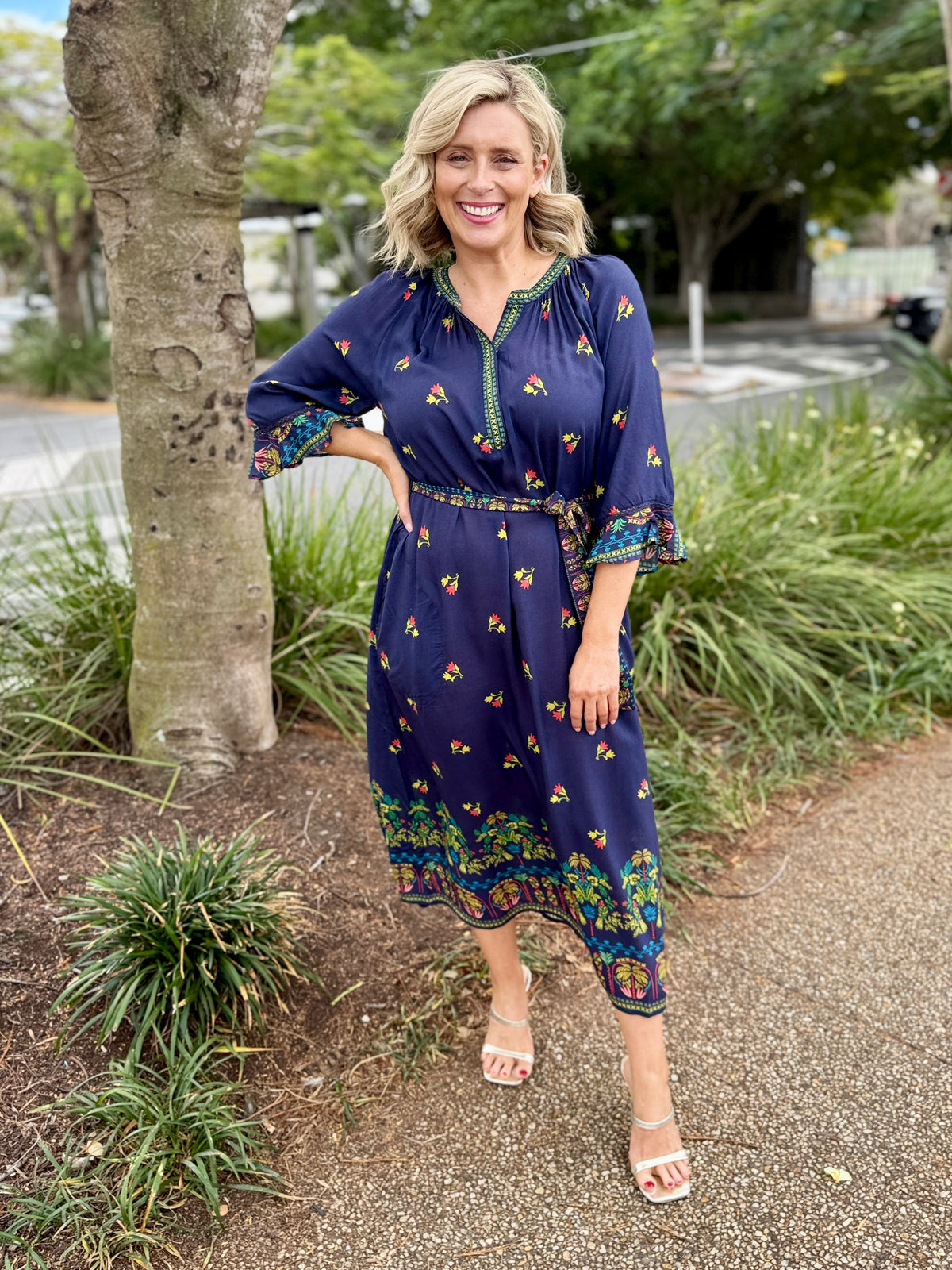 navy blue midi dress with colorful floral prints and green trim 