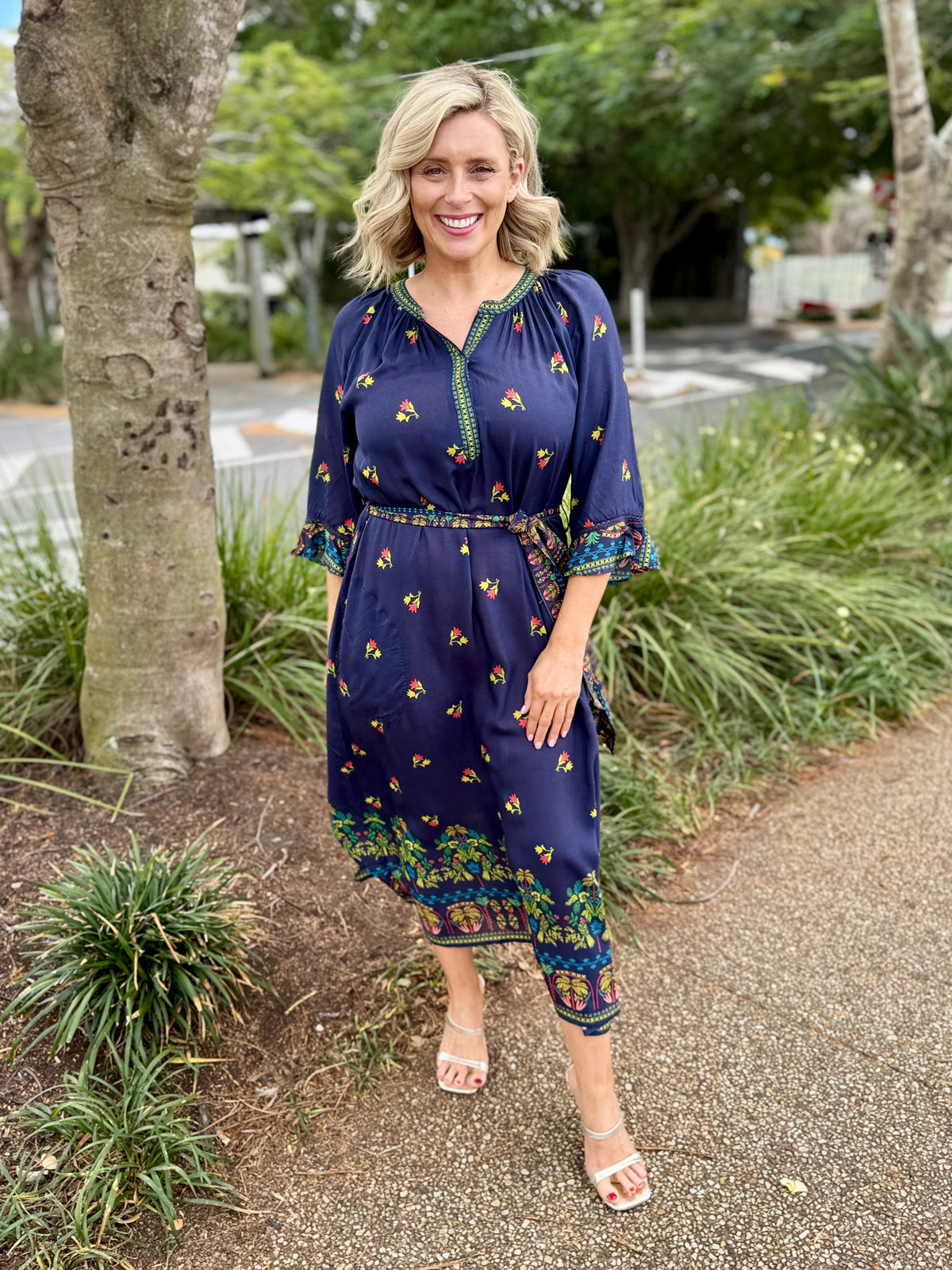 navy blue midi dress with colorful floral prints and green trim 