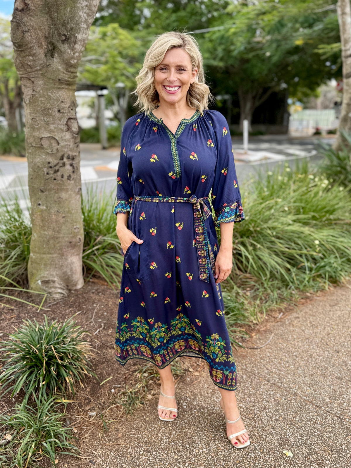 navy blue midi dress with colorful floral prints and green trim 