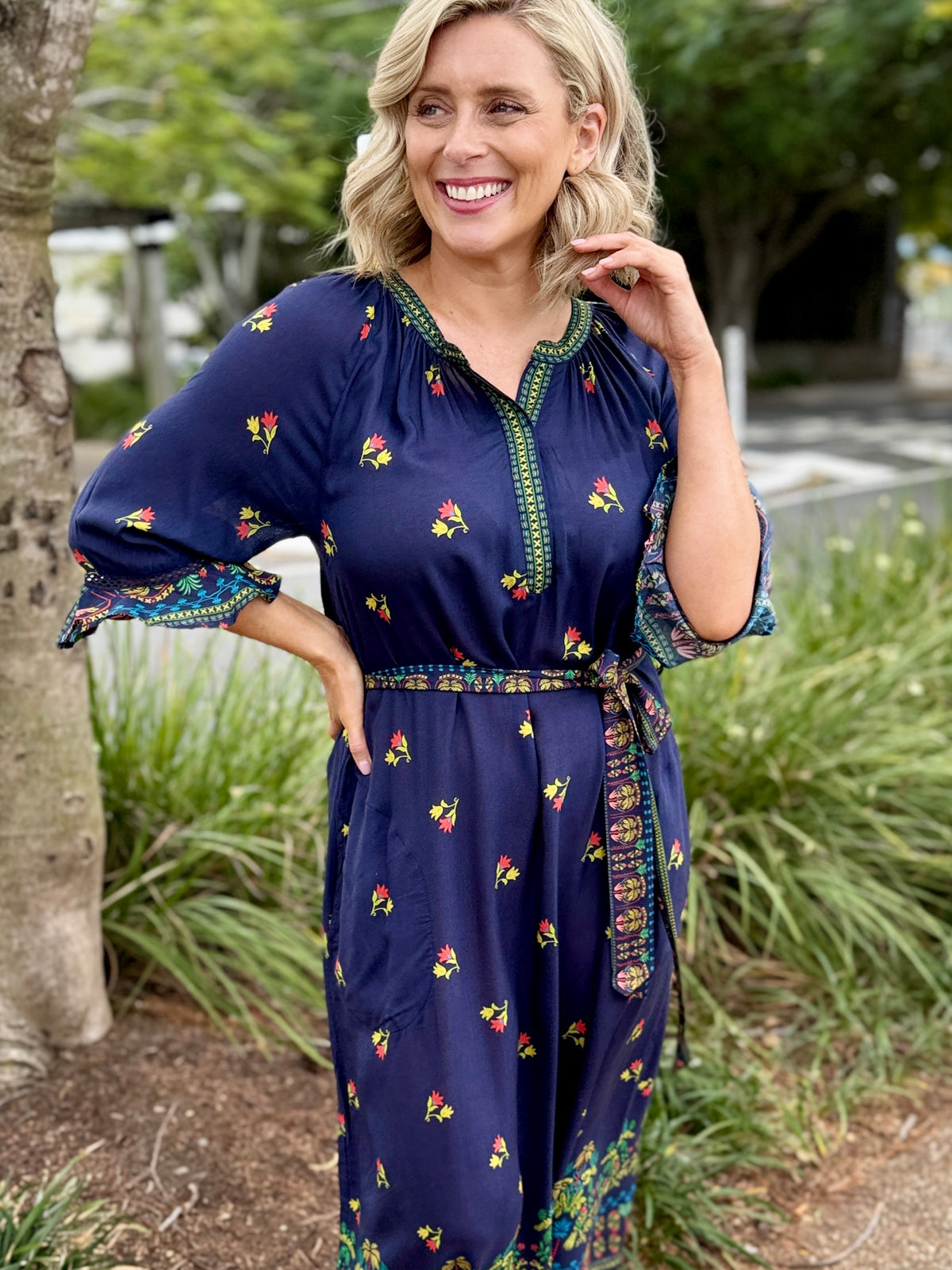 navy blue midi dress with colorful floral prints and green trim 