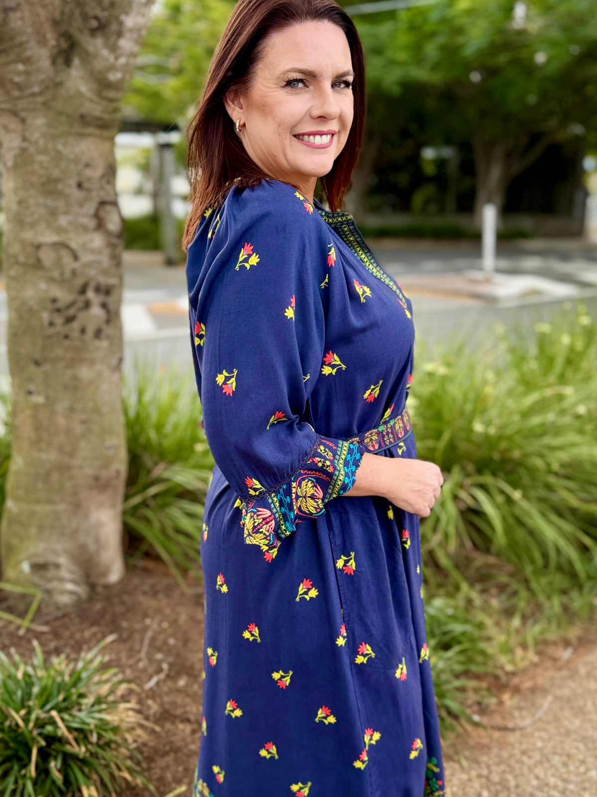 navy blue midi dress with colorful floral prints and green trim 