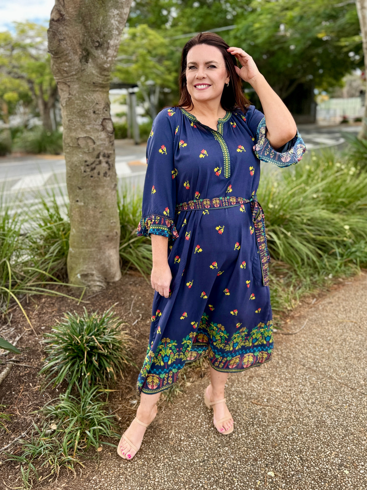 navy blue midi dress with colorful floral prints and green trim 