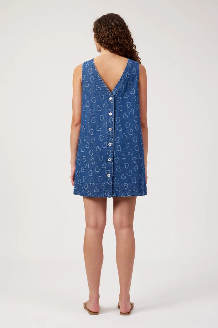 sleeveless blue dress with a white heart pattern and a buttoned V-neckline