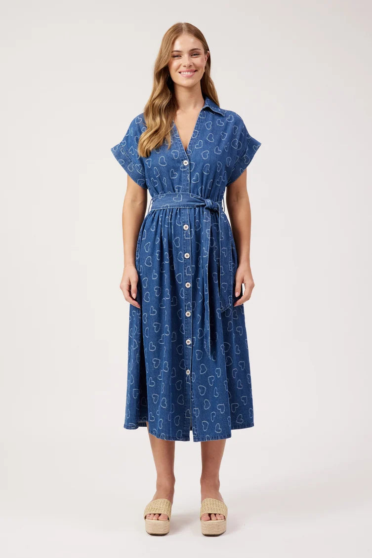 A woman modeling a blue midi dress with a white paisley pattern, short flutter sleeves, a button-down front, and a matching fabric tie belt