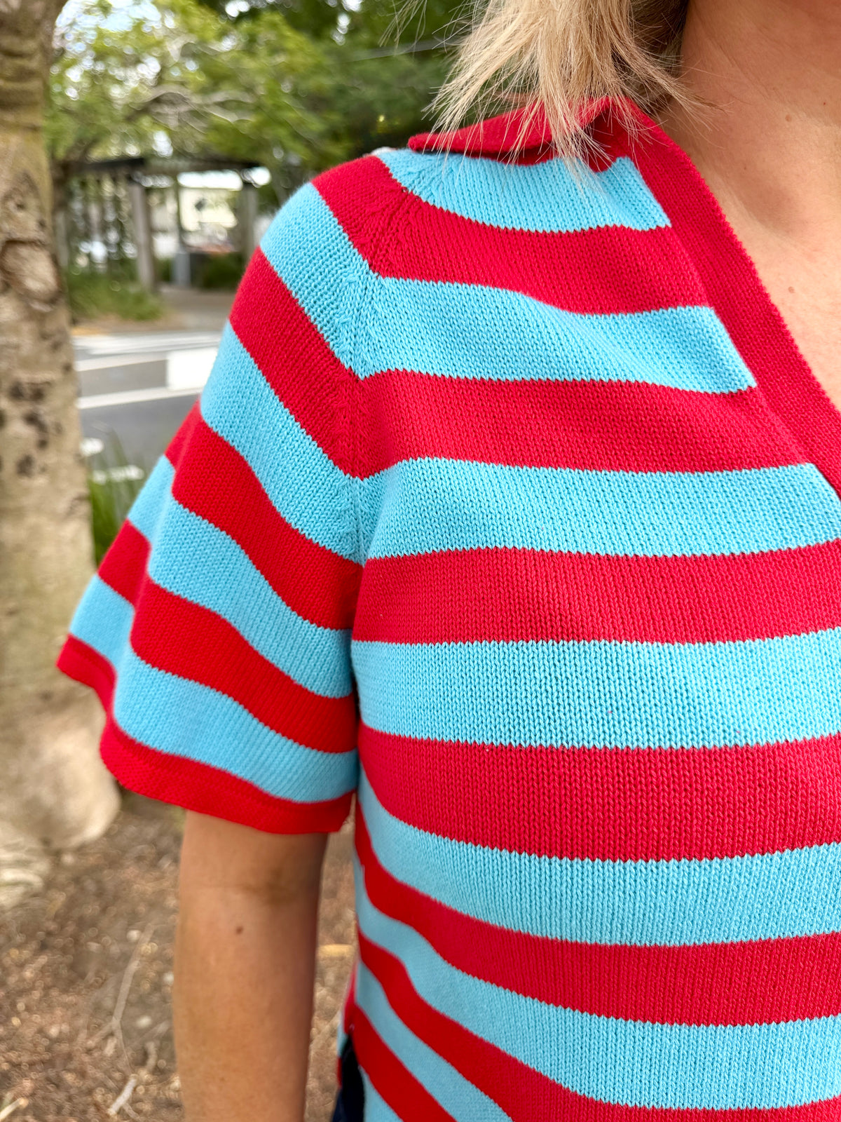  red and light blue horizontally striped short-sleeve V-neck top with dark denim shorts, 