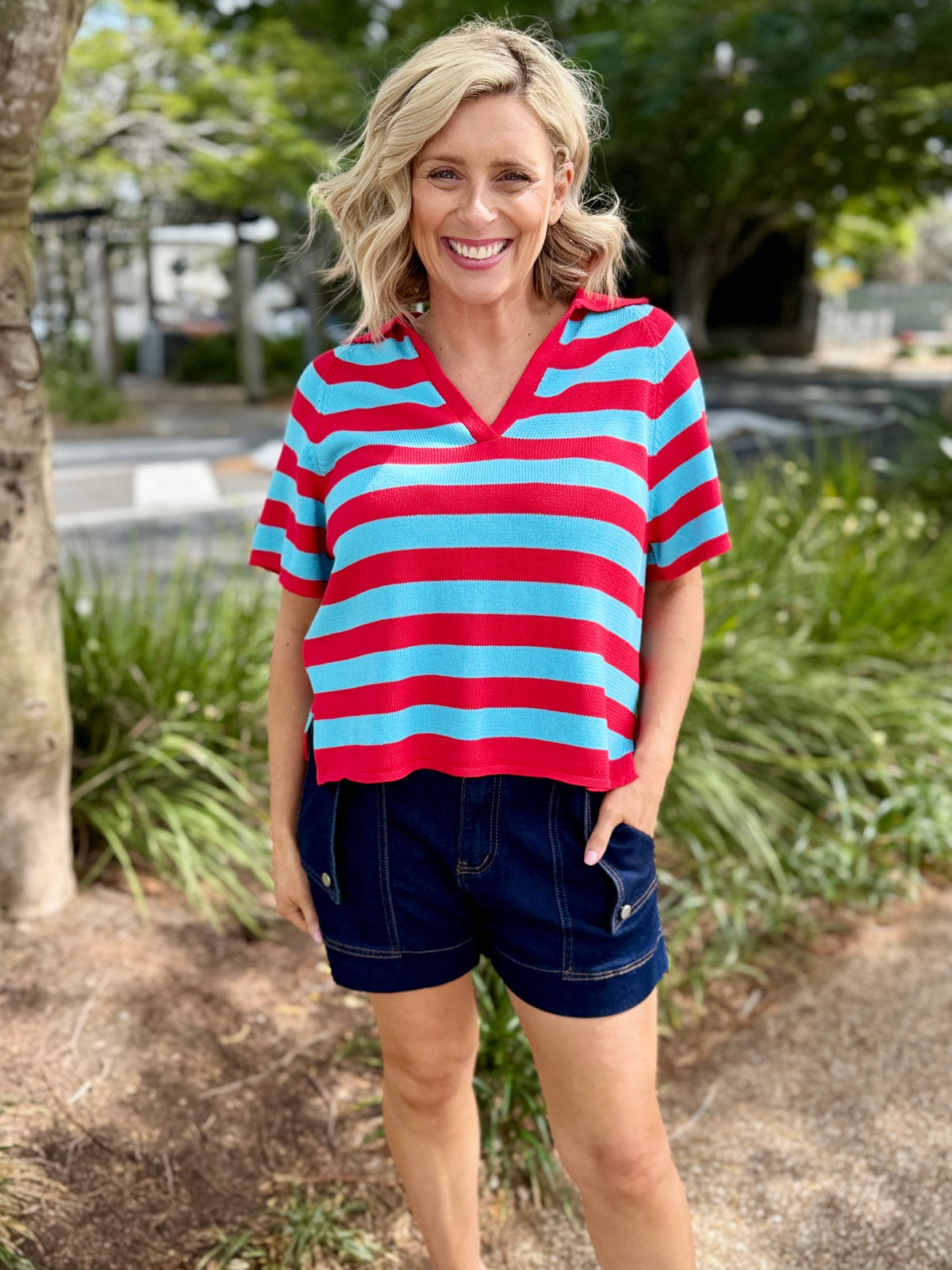  red and light blue horizontally striped short-sleeve V-neck top with dark denim shorts, 
