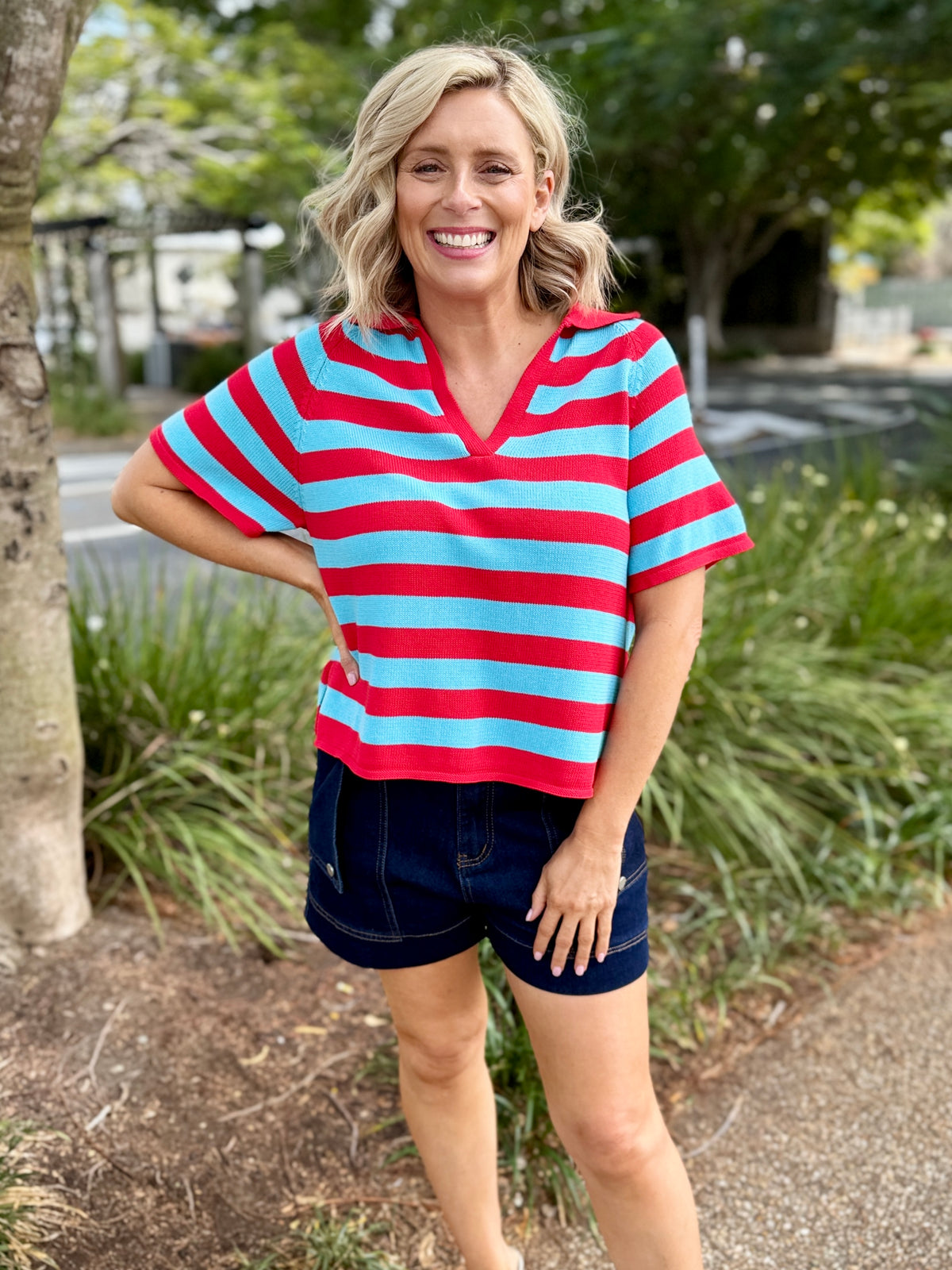  red and light blue horizontally striped short-sleeve V-neck top with dark denim shorts, 