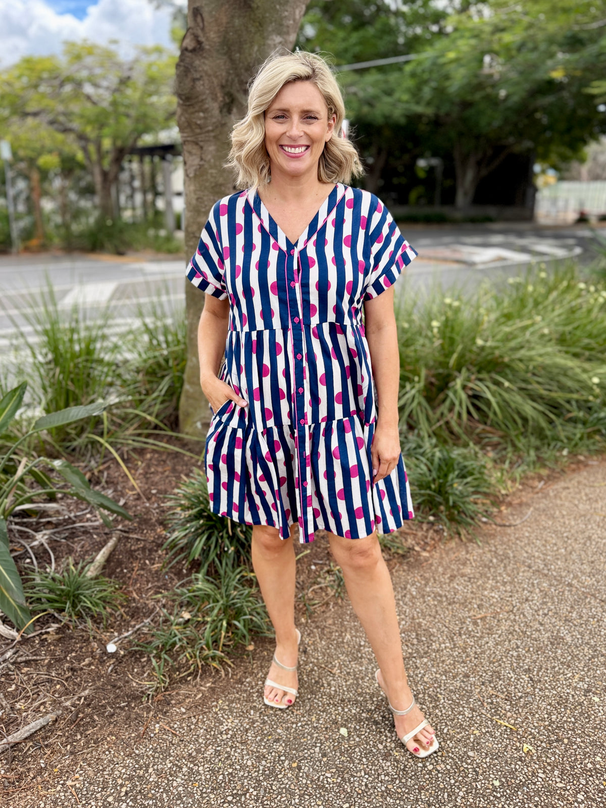 short-sleeve V-neck romper with vertical navy, white, and pink stripes, 