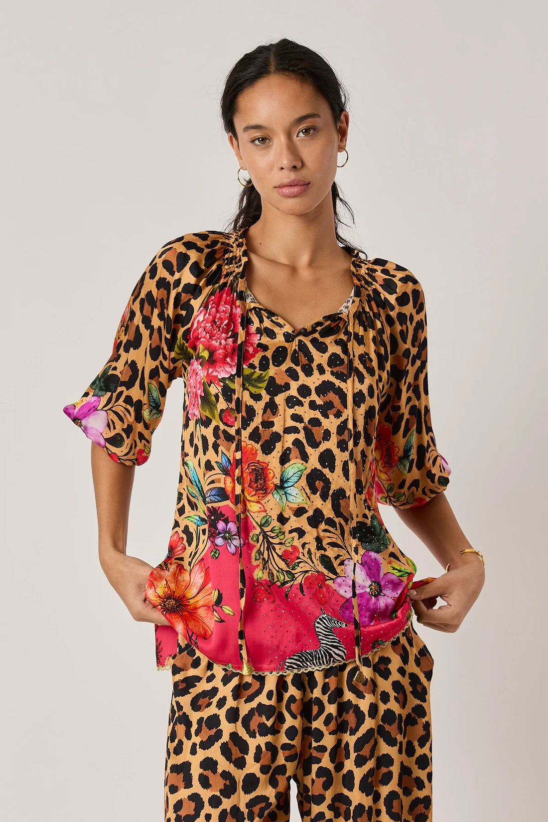  long-sleeve blouse with a leopard print upper section and a bright pink tropical floral print lower section