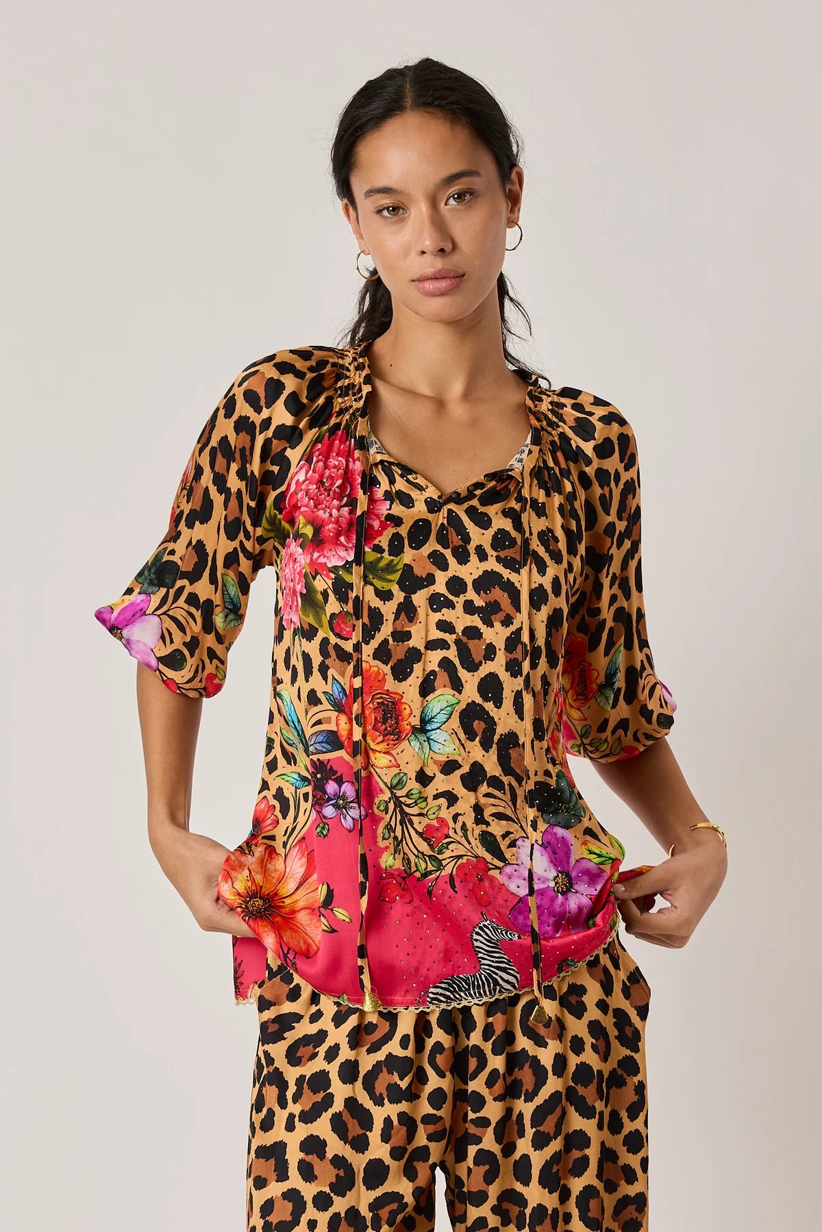  long-sleeve blouse with a leopard print upper section and a bright pink tropical floral print lower section